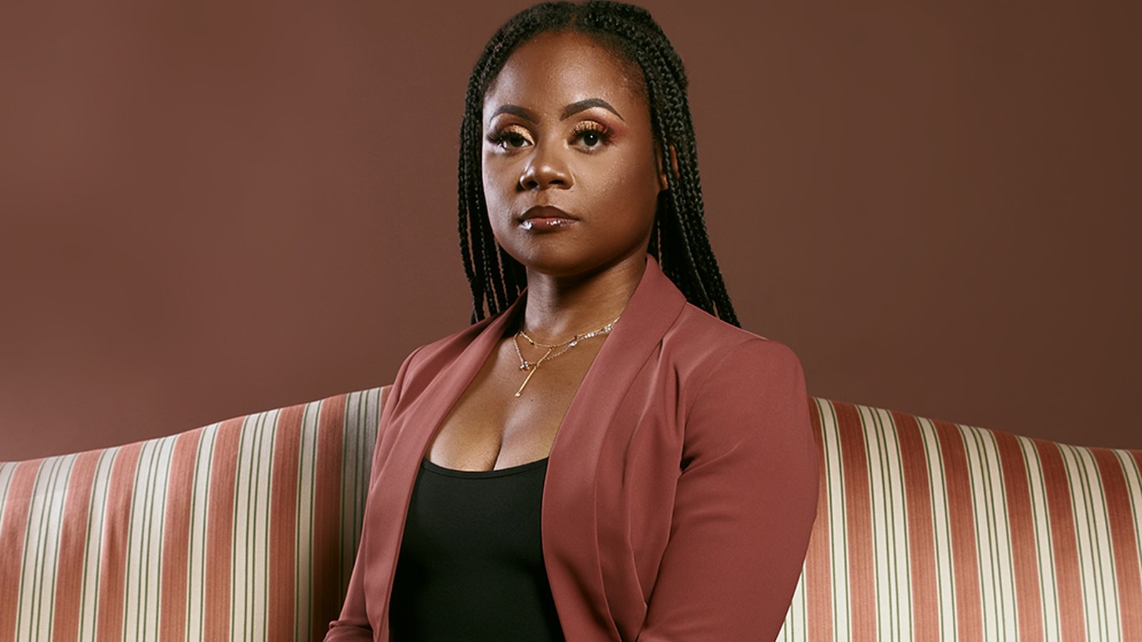 La-Tisha Pirtle, President and Co-Founder of MVGeneral Construction Services, seated and facing the camera in a rust-colored blazer.